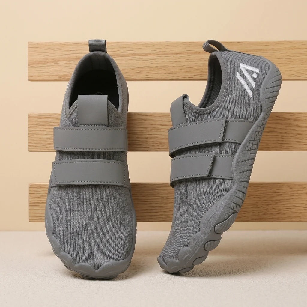 Alvidon LiftPur Grau – Schuhe für Krafttraining, an drei hellen Holzlatten gelehnt, Barfußschuhe für Damen und Herren
